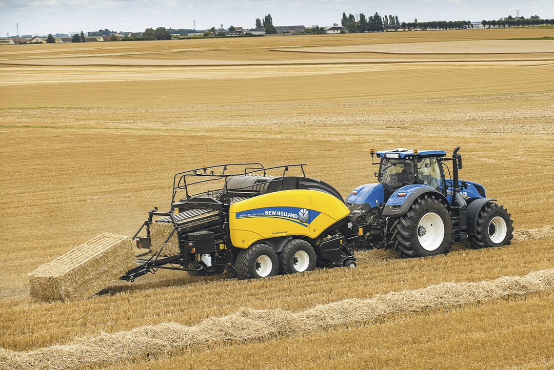 Vista lateral de la empacadora New Holland BigBaler 1290 Plus en funcionamiento sobre un rastrojo.