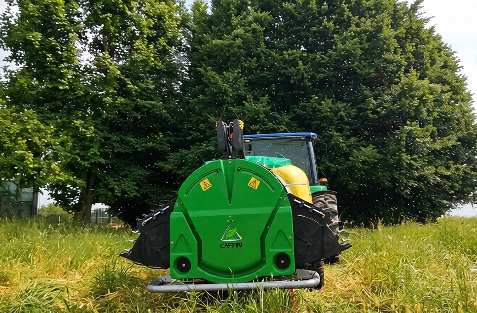 Tractor remolcando atomizador agrícola Caffini con deflectores de aire entre hileras de árboles