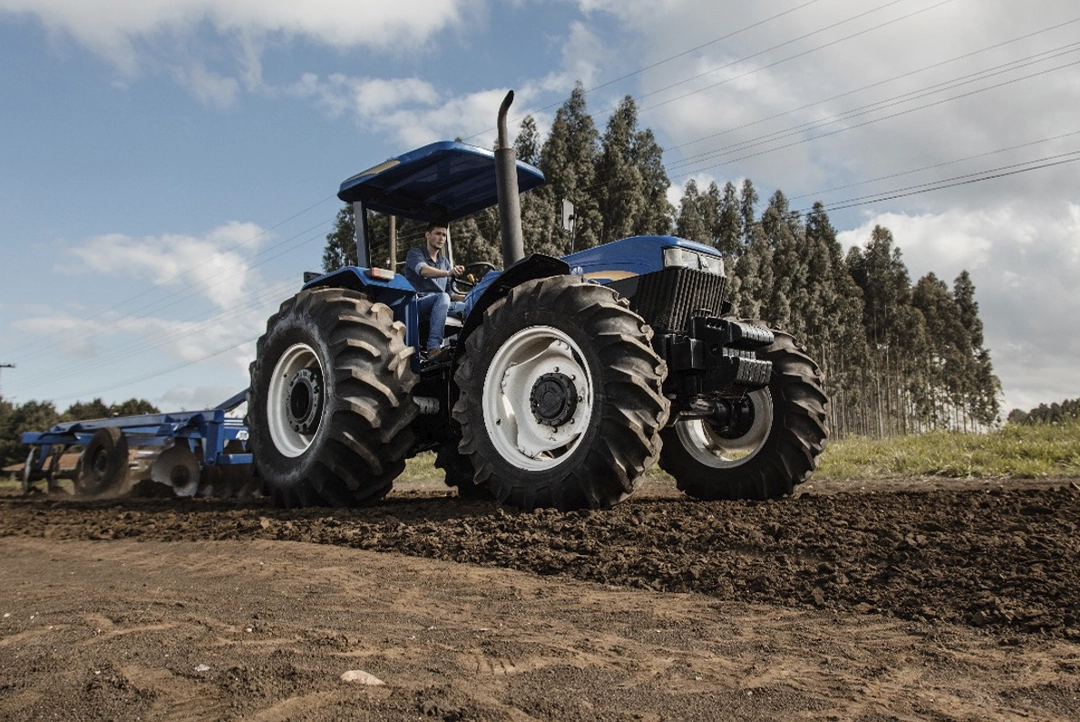 Tractor New Holland 8030 azul con rastra de discos preparando la tierra para cultivo