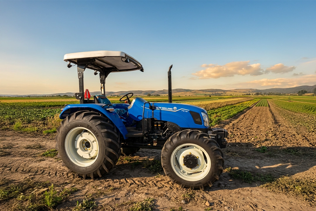Tractor agrícola New Holland TT4.75 4WD trabajando en campo de cultivo.