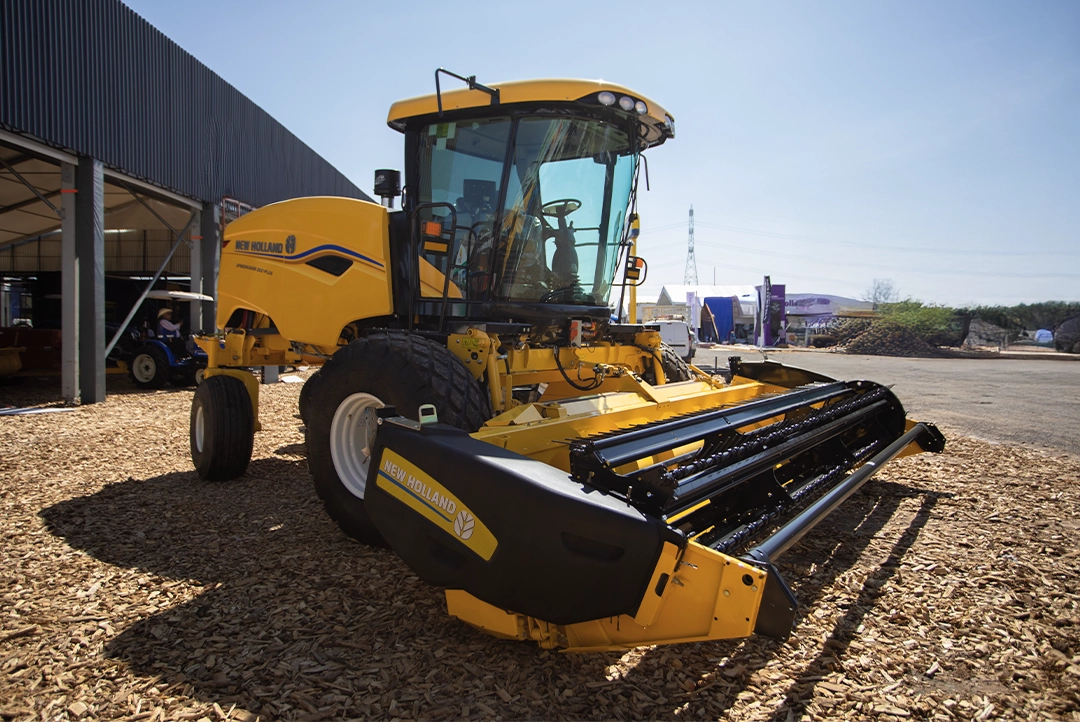 Vista lateral trasera de la segadora autopropulsada New Holland Speedrower 200 Plus en exhibición.