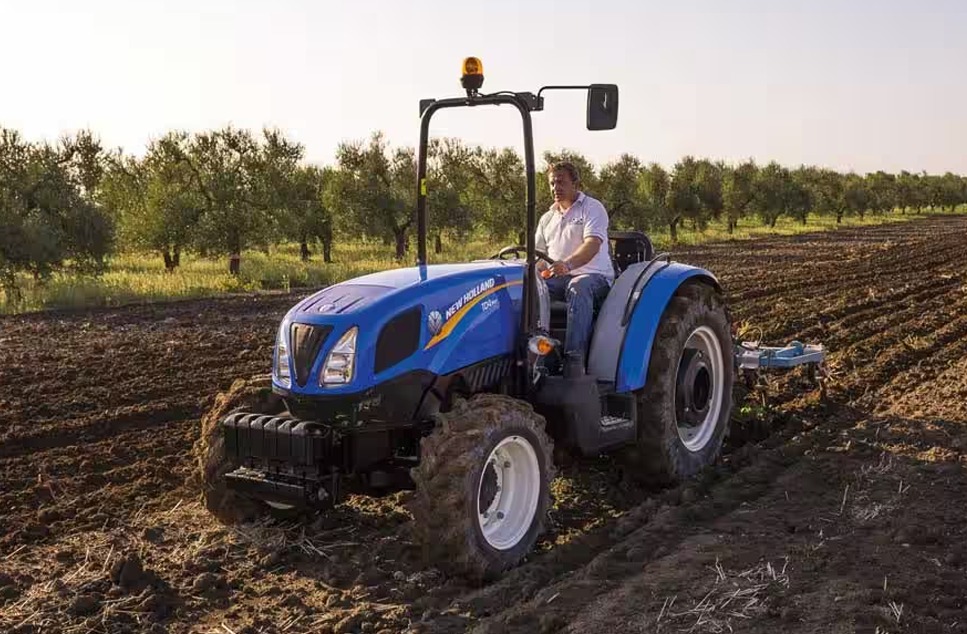 Agricultor trabajando con un tractor New Hollan en el campo
