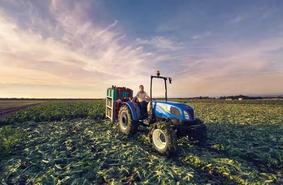 Tractor agrícola New Holland en un atardecer
