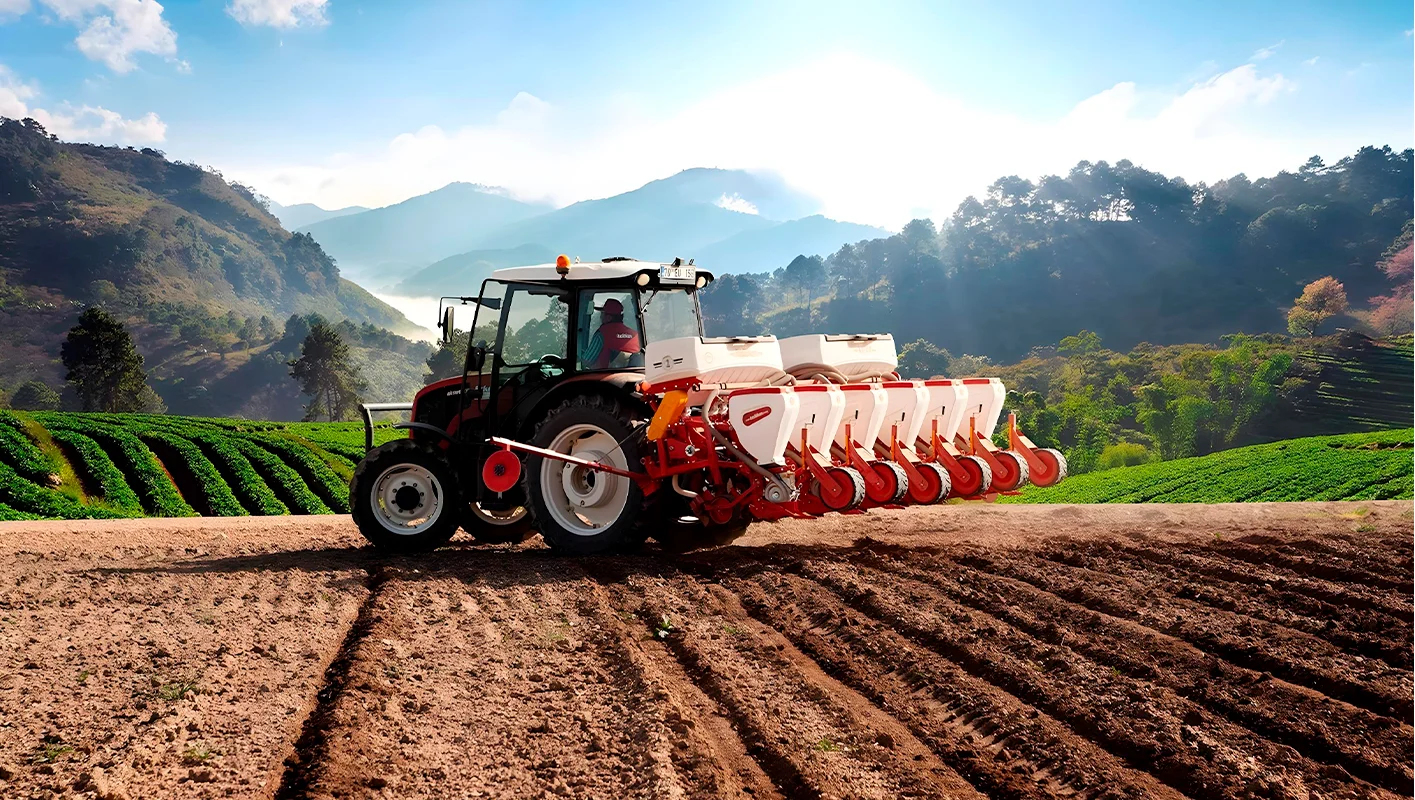 Un tractor trabajando en el campo con una sembradora agrícola de precisión.